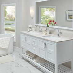 a white bathroom with two sinks and a tub