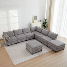 a living room with a sectional couch and ottoman