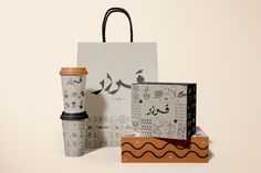 a coffee cup, paper bag and other items are on display in front of a white background