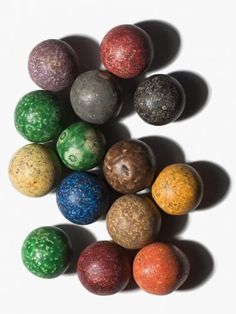 an assortment of different colored balls on a white surface