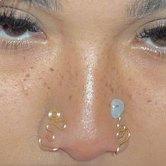 a close up of a person's nose with piercings on their nose rings