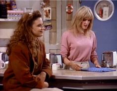 two women sitting at a counter talking to each other