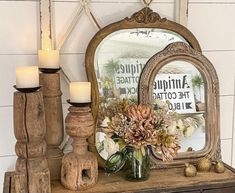 a mirror and some candles are sitting on a table next to a dresser with an antique sign