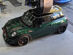 a green mini cooper parked in a garage