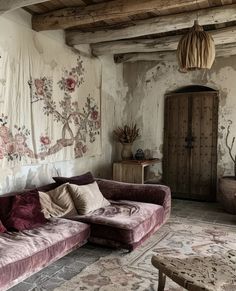 a living room filled with furniture next to a wall covered in floral fabric and curtains