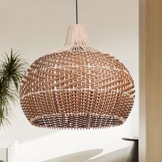 a wooden light hanging from the ceiling in a room with white walls and potted plants