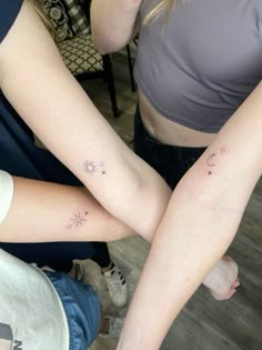 two girls with matching tattoos on their arms