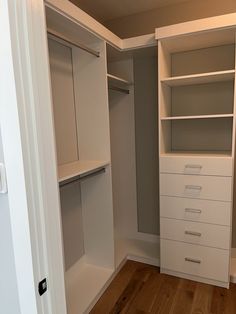 an empty white closet with drawers and shelves