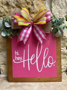 a pink sign that says hi hey hello with a bow on it and succulents