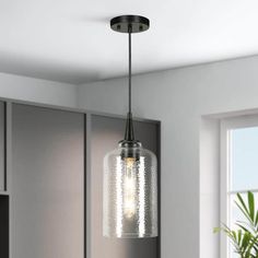 a light fixture hanging from the ceiling in a kitchen with gray cabinets and white walls