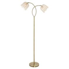 a brass floor lamp with three glass shades on the lampshade and a round base