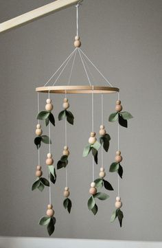 a mobile with wooden beads and leaves hanging from it