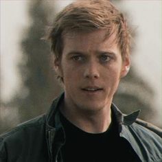 a close up of a person wearing a jacket and looking at the camera with a serious look on his face