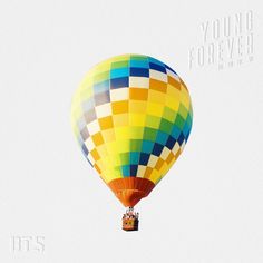 a multicolored hot air balloon flying in the sky with words young forever above it