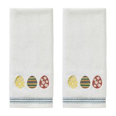 two white towels with colorful eggs on them