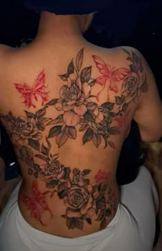 the back of a woman's body with flowers and butterflies on it