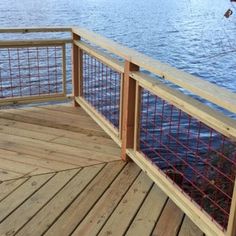 a wooden deck next to the water with metal railings on it's sides