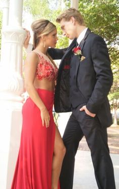 a man and woman in formal wear standing next to each other near a white pillar