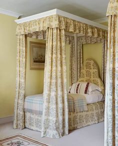 a four poster bed in a bedroom with yellow walls