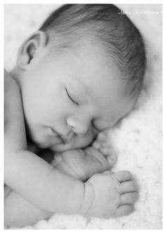 a black and white photo of a baby sleeping