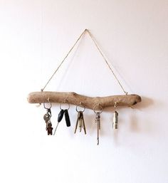 several keys hang from a branch on a wall