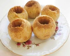 four doughnuts are on a plate with flowers