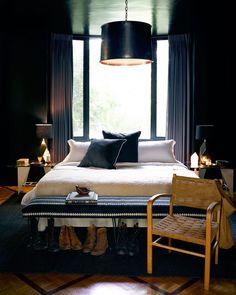 a bedroom with black walls and white bedding