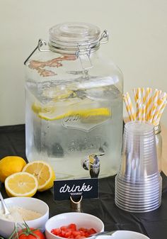 a table topped with plates and bowls filled with food next to a large glass jar