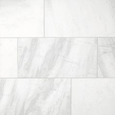 a white marble tile wall that looks like it has been cleaned and is ready to be used