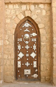 an ornate wooden door with metal decorations on it