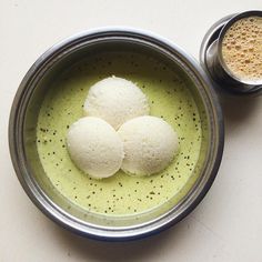 three balls of food in a bowl next to a cup