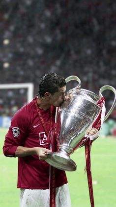 a soccer player kissing the trophy on the field