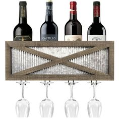 three wine glasses and four bottles in front of a wooden paneled wall mounted wine rack