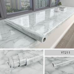 the counter top is white marble and has two rolls of paper on it, along with a window in the background