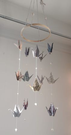 a group of origami birds hanging from a chandelier in a room