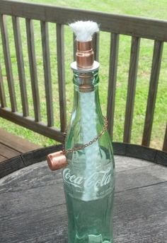 a green glass bottle sitting on top of a wooden table