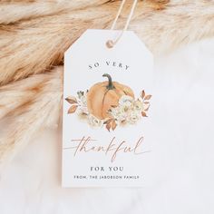 a thank card with an orange pumpkin and white flowers is on a furnishing