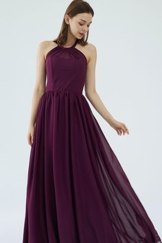 a woman wearing a long purple dress with halter neckline and pleaed skirt