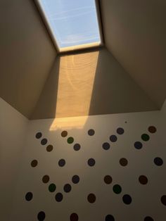 the skylight is shining brightly in an empty room with polka dots on the wall