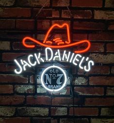 a neon sign that reads jack daniels'old no 7 brand on a brick wall