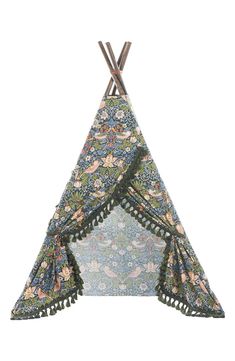 a teepee that is made out of fabric and has flowers on the front, with tassels hanging from it