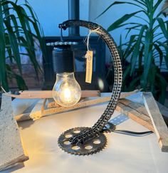 a light that is sitting on top of a table next to a lamp bulb and chain