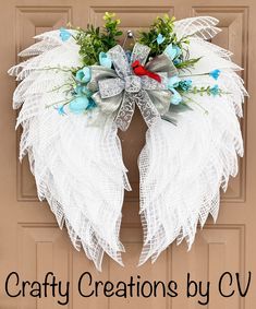 a white wreath with blue and red flowers on it that says crafty creations by cv