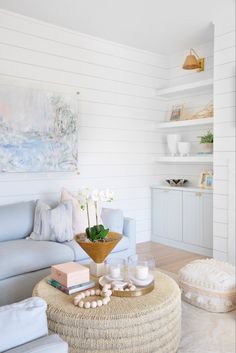 a living room filled with furniture and a large painting on the wall above it's coffee table