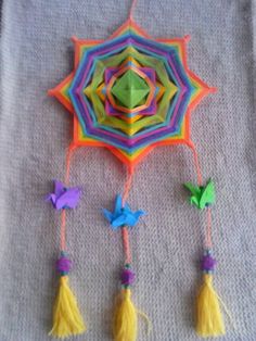 an origami kite with tassels and birds hanging from it