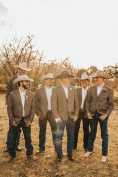 a group of men wearing hats standing next to each other in the middle of a field