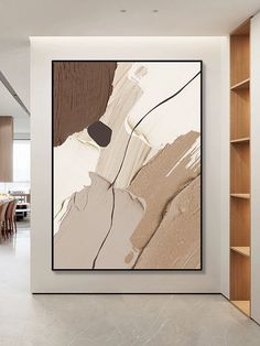 an abstract painting hangs on the wall next to a bookshelf and dining room table