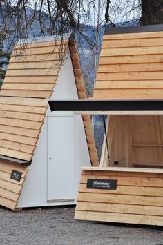 two wooden buildings with windows on the top and one in the middle that is made out of plywood