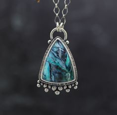 This necklace features an petrified opalized wood triangle. It is a stunning stone with intense color. I have set this point up with a fringe of silver balls at it's base and textured the reverse side. Pendant measures 1 3/4 inches long and 1 inch wide at its widest. ♦Chain: This comes with a diamond link chain and is 18-20 inches with a lobster claw clasp and 2 inch extension chain. If you would like another length please send me a message and I will be happy to adjust this. ♦ Metal: Sterling s Silver Crystal Pendant Necklace With Gemstone Accents, Luxury Oxidized Finish Pendant Necklace, Silver Faceted Crystal Pendant Necklace, Artisan Silver Pendant Gemstones, Elegant Patina Pendant Necklace, Artisan Silver Pendant Crystal Necklace, Stone Pendant Necklace, Wood Pendant, Silver Pendant Necklace