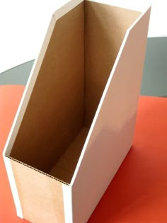 an open cardboard box sitting on top of a red and black tableclothed surface